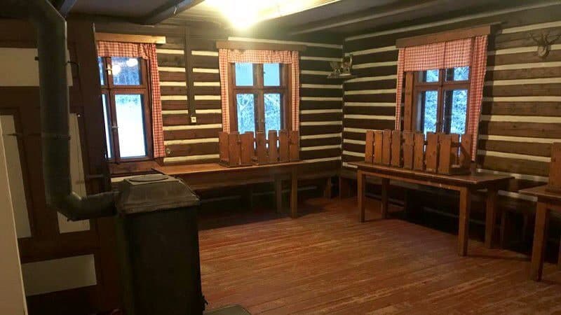 Klubovna Hubertky s roubenými stěnami a dřevěnými lavicemi
